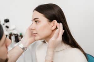 Young woman having her ears examined prior to otoplasty surgery