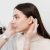 Young woman having her ears examined prior to otoplasty surgery