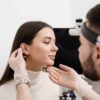 Woman having her ears examined by a doctor before her ear surgery to correct stretched lobes